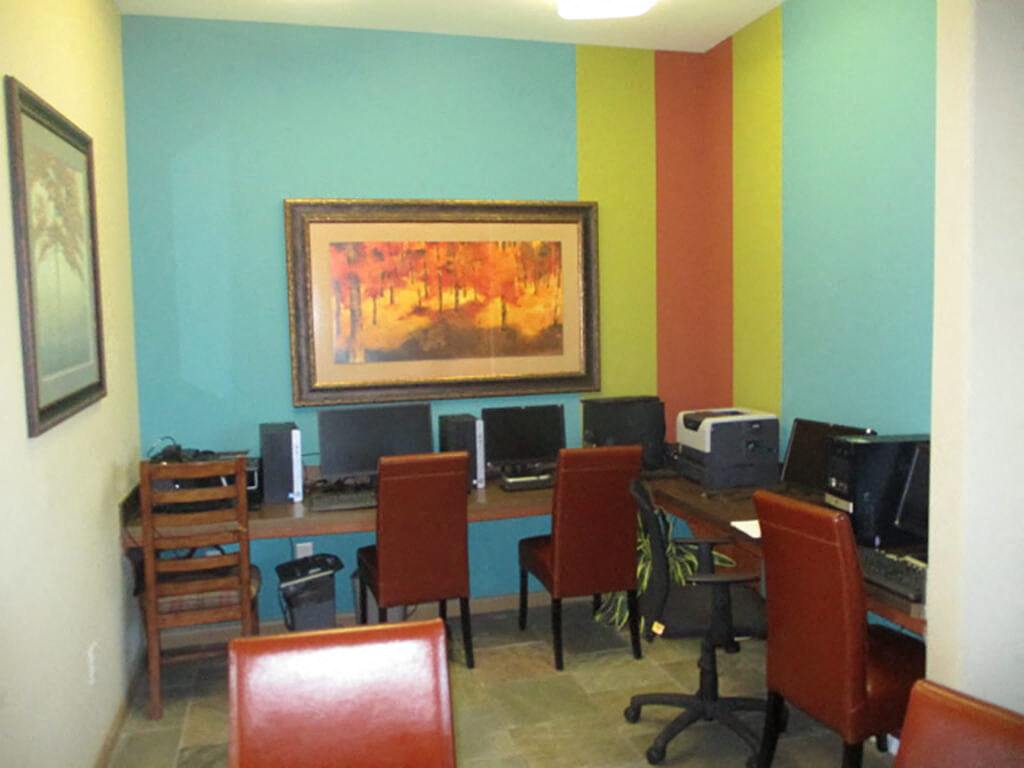 The computer room with a bright accent wall at the Parkway Ranch Apartments in Houston, Texas.